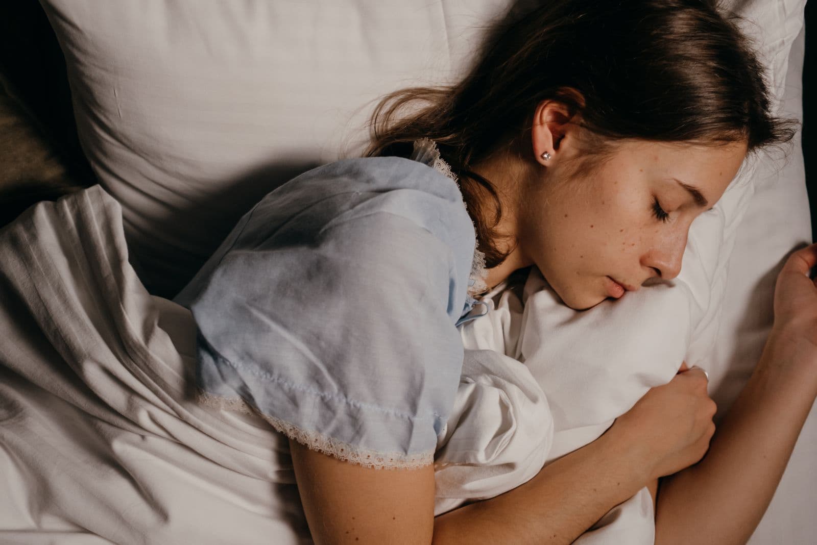 Woman sleeping peacefully in a softly lit bedroom