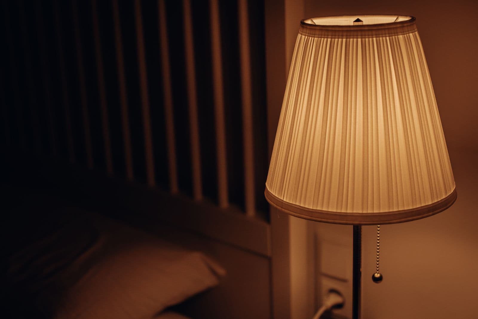 Dim bedside lamp in a dark bedroom