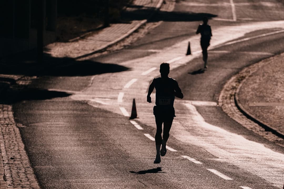 Runners in silhouette on a winding road