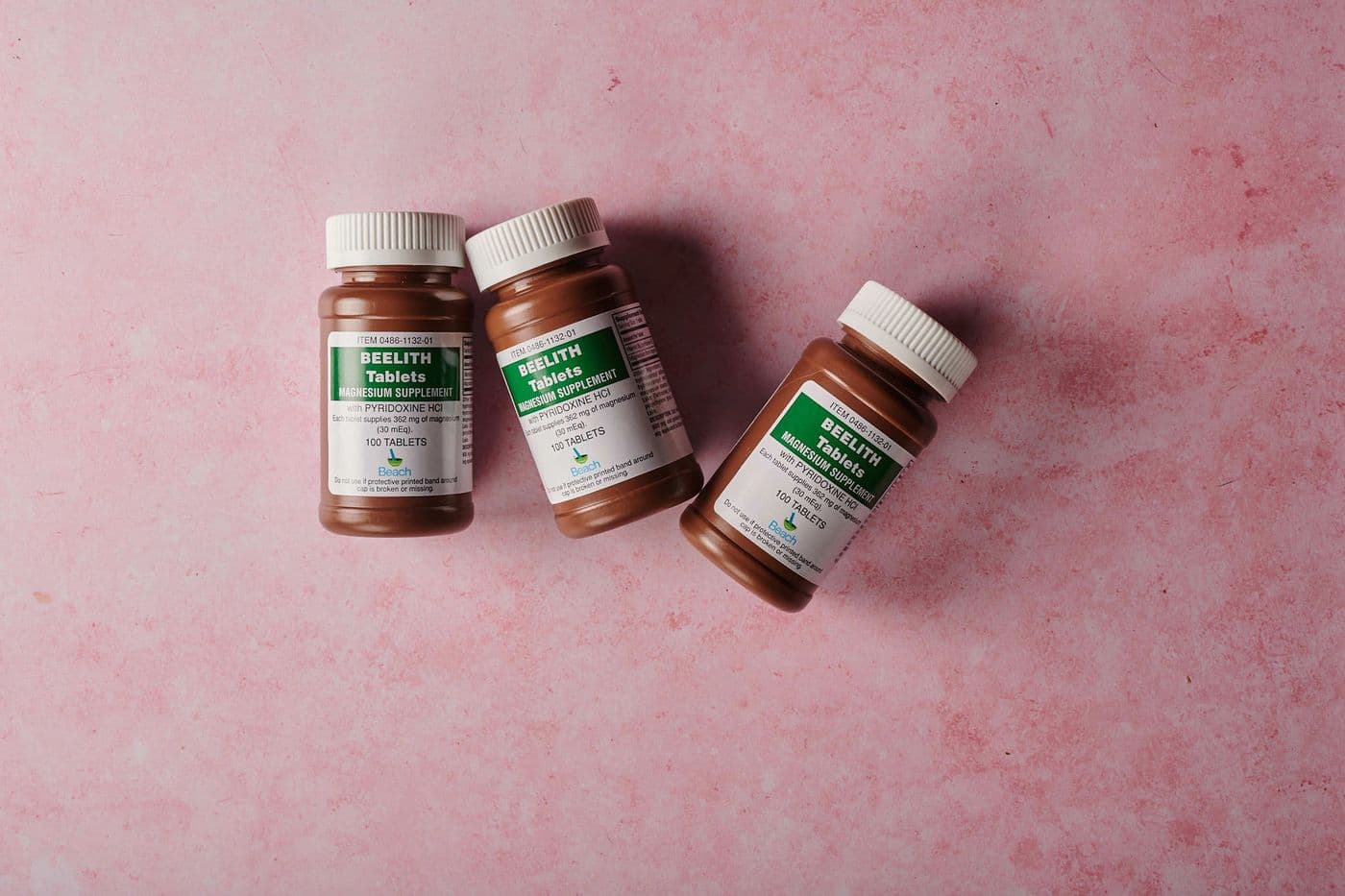 Brown supplement bottles on a soft pink background